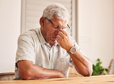 Buy stock photo Stress, headache and old man at table in home with glasses, worry and fatigue in retirement. Debt, anxiety and tired, frustrated senior person with mental health problem or crisis, exhausted and sad.