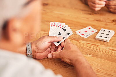 Buy stock photo Hands, cards and a senior man playing poker at a table in the living room of a retirement home. Gambling, planning and fun with an elderly male pensioner in a house closeup for entertainment games