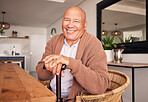 Portrait, walking stick and a senior man with a disability sitting in the living room of his home during retirement. Smile, cane and relax with an elderly person at the dining room table in his house