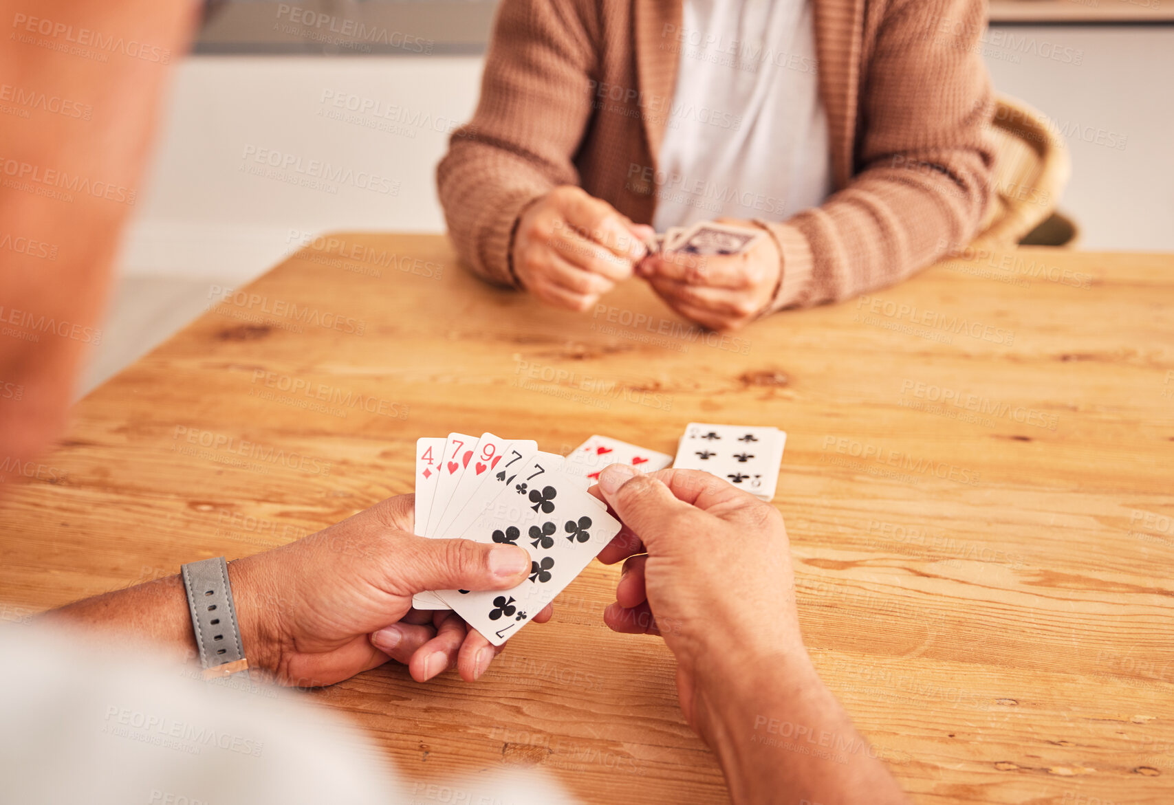 Buy stock photo Hands, cards and a senior man playing a game at a table in the living room of a retirement home. Thinking, planning and fun with an elderly male pensioner in a house closeup for entertainment