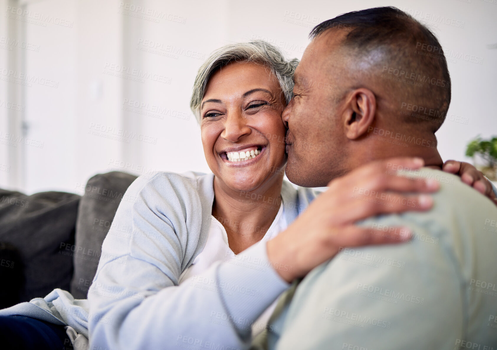 Buy stock photo Love kiss, face and elderly couple happiness, romantic bond and enjoy quality time together, smile and retirement wellness. Living room sofa, care and senior man, old woman or people happy at home