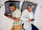 Above, couple and phone in bed for social media, communication and busy with technology. Ignore, chat and a senior man and woman with mobile in the bedroom for an app or internet together in marriage