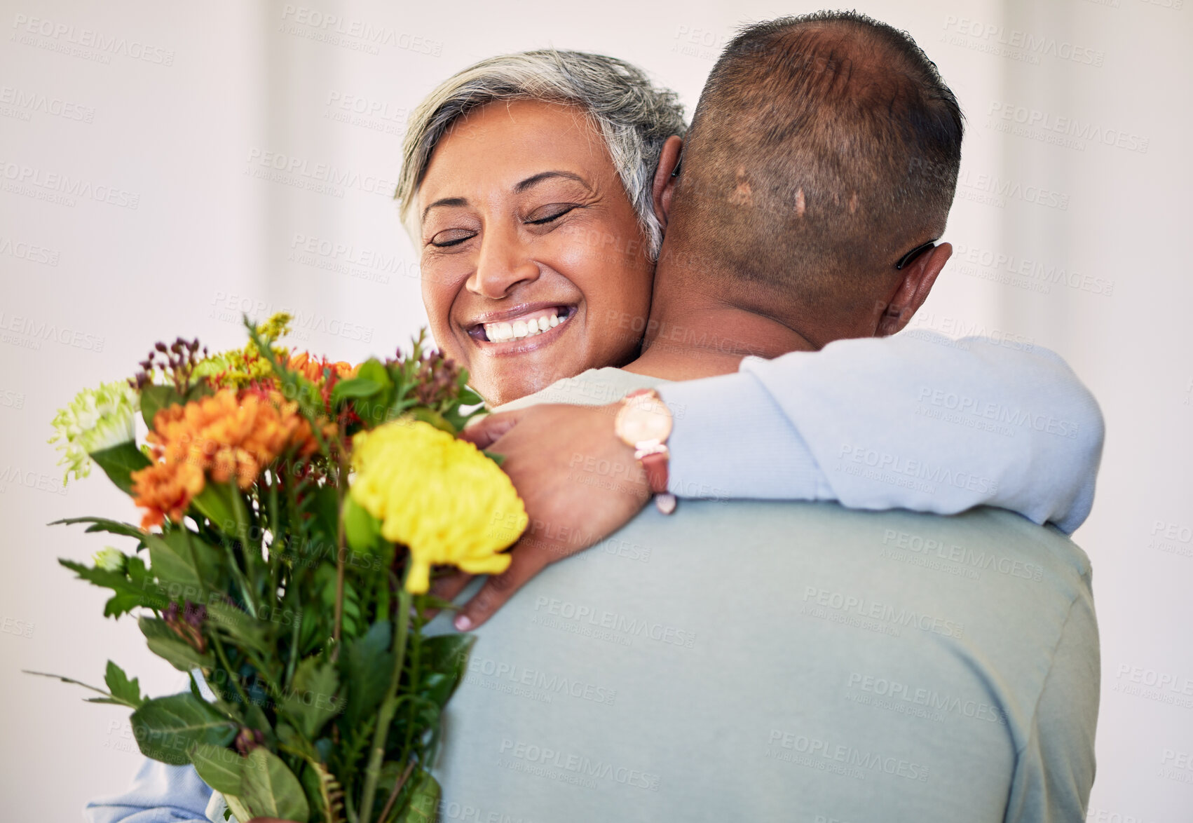 Buy stock photo Flower bouquet, elderly couple hug or gift for happy anniversary, special event or marriage love, care and support. Home bond, sorry and elderly woman, man or excited people smile with floral present