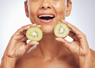 Excited, face and senior woman with kiwi in studio isolated on a white background. Food, fruit and natural model with nutrition for skincare, diet and vitamin c for anti aging, cosmetics or health