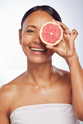 Buy stock photo Skincare, face and mature woman with grapefruit in studio isolated on a white background. Portrait, natural fruit and happy model with food for nutrition, wellness and healthy diet for anti aging.