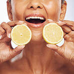 Closeup, orange and senior woman with skincare, cosmetics and dermatology on a studio background. Zoom, female person or model with citrus fruit, treatment and natural beauty with vitamin c or health