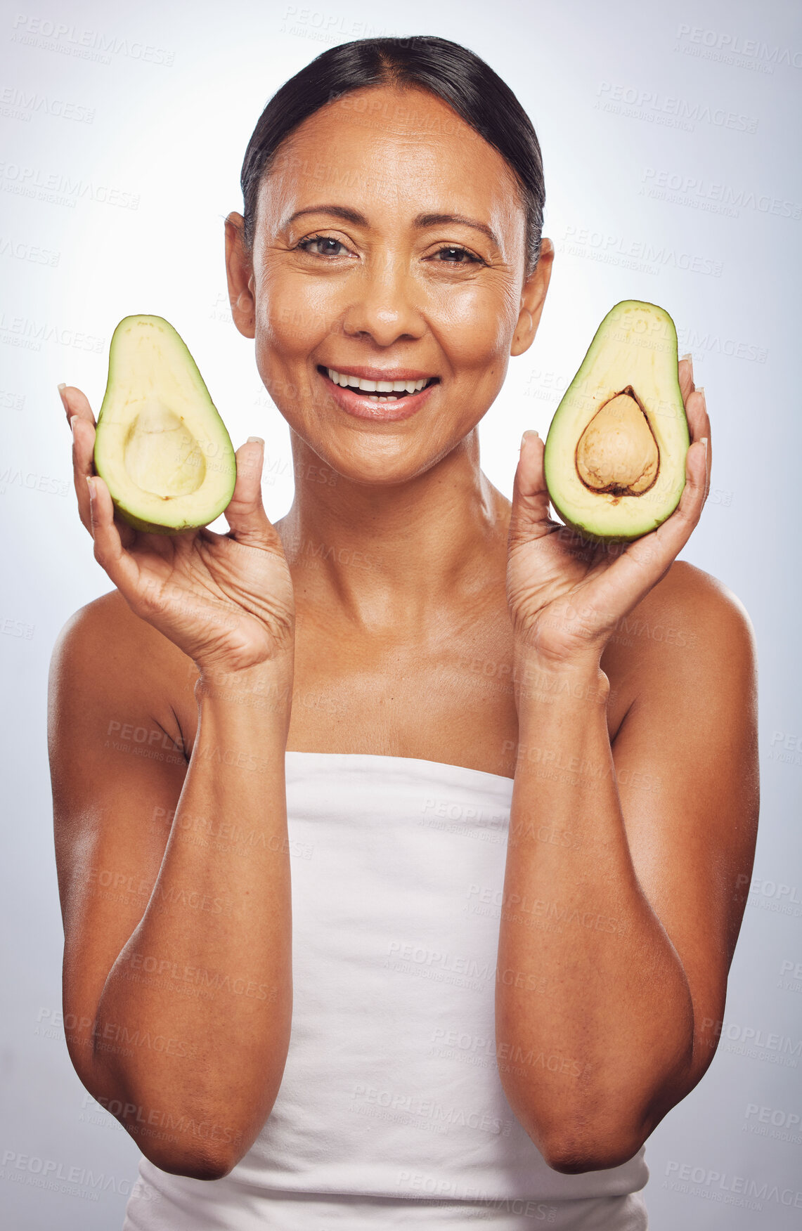 Buy stock photo Portrait, skincare and senior woman with avocado in studio isolated on a white background. Face, natural fruit and happy model with food for vegan nutrition, healthy diet and omega 3 for anti aging.