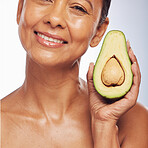 Skincare, face and mature woman with avocado in studio isolated on a white background. Portrait, natural fruit and happy model with food for organic nutrition, healthy diet and omega 3 for anti aging