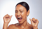 Dental flossing, portrait or mature woman cleaning teeth for beauty or wellness in studio on white background. Wink, self care or healthy senior female model grooming her tooth or mouth for hygiene 