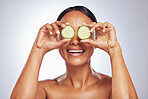 Cucumber, face and natural beauty of happy woman in studio, white background and healthy diet. Female model, skincare and fruits on eyes for sustainable cosmetics, aesthetic dermatology and nutrition