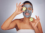 Portrait, cucumber and mask with a model woman in studio on a gray background for an antiaging facial treatment. Beauty, skincare and fruit with a young female person using cosmetic lay on her face