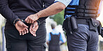 Handcuffs, crime and police with man criminal outdoors for arrested, corruption and justice. Illegal, arrest and Law enforcement with suspect for money laundering, violence or fraud, robbery or jail