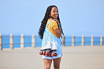 Portrait, back and roller skating with a black woman by the sea, on the promenade for training or recreation. Beach, sports or fun with a happy young teenager holding skates on the coast by the ocean