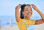 Portrait, smile and hair with a black woman on a blurred background by the ocean during summer vacation. Face, happy and braids with a young female person outdoor on the promenade for a holiday