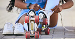 Roller skates, hands and tie shoes on the ground to start exercise, workout or training outdoor. Skating, person and tying sneakers to get ready for sports on street to travel, journey and fitness.