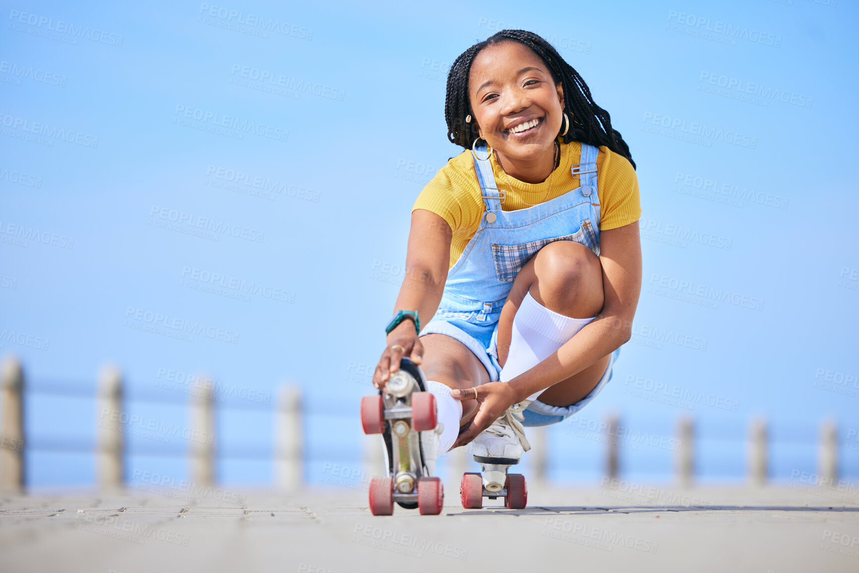 Buy stock photo Portrait, roller skating and balance with a black woman by the sea, on the promenade for training or recreation. Beach, sport and smile with a happy young teenager in skates on the coast by the ocean