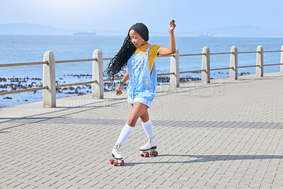 Roller skating, fun or freedom with a black woman by the sea, on the promenade for training or recreation. Beach, sports and a young female teenager in skates on the coast by the ocean or water