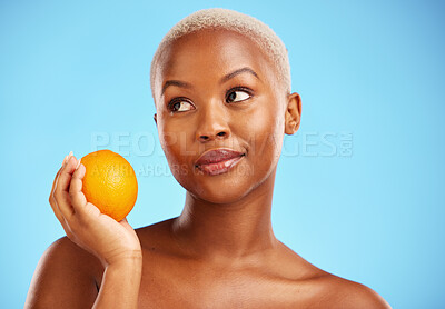 Buy stock photo Orange, thinking and black woman with skincare, natural beauty and vitamin c against a blue studio background. Female person, ideas and model with citrus fruit, health and wellness with dermatology