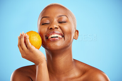 Buy stock photo Orange, funny and black woman with skincare, dermatology or cosmetics on a blue studio background. Female person, humor or model with citrus fruit, health or wellness with vitamin c or natural beauty