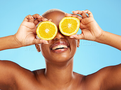 Buy stock photo Orange, beauty and smile with a model black woman in studio on a blue background for a facial. Food, skincare and natural with a happy young female person holding a snack for health or wellness