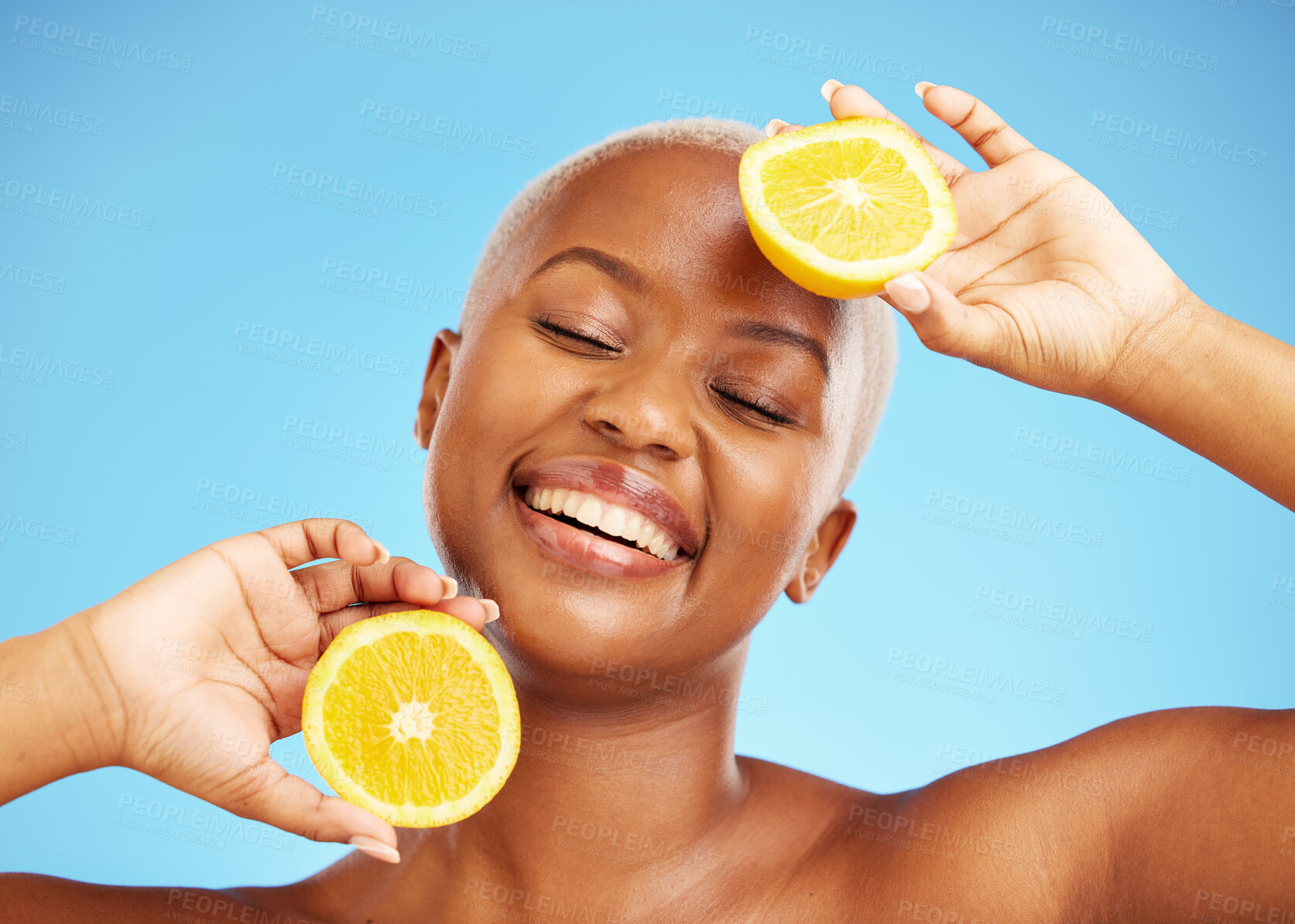 Buy stock photo Orange, face and nutrition with a model black woman in studio on a blue background for treatment. Beauty, skincare and smile with a happy young person holding natural fruit for health or wellness