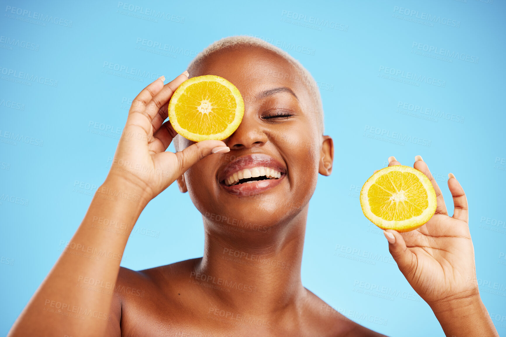 Buy stock photo Skincare, orange and smile with a model black woman in studio on blue background for treatment. Face, beauty and fruit with a happy young female person holding a slice for natural health or wellness