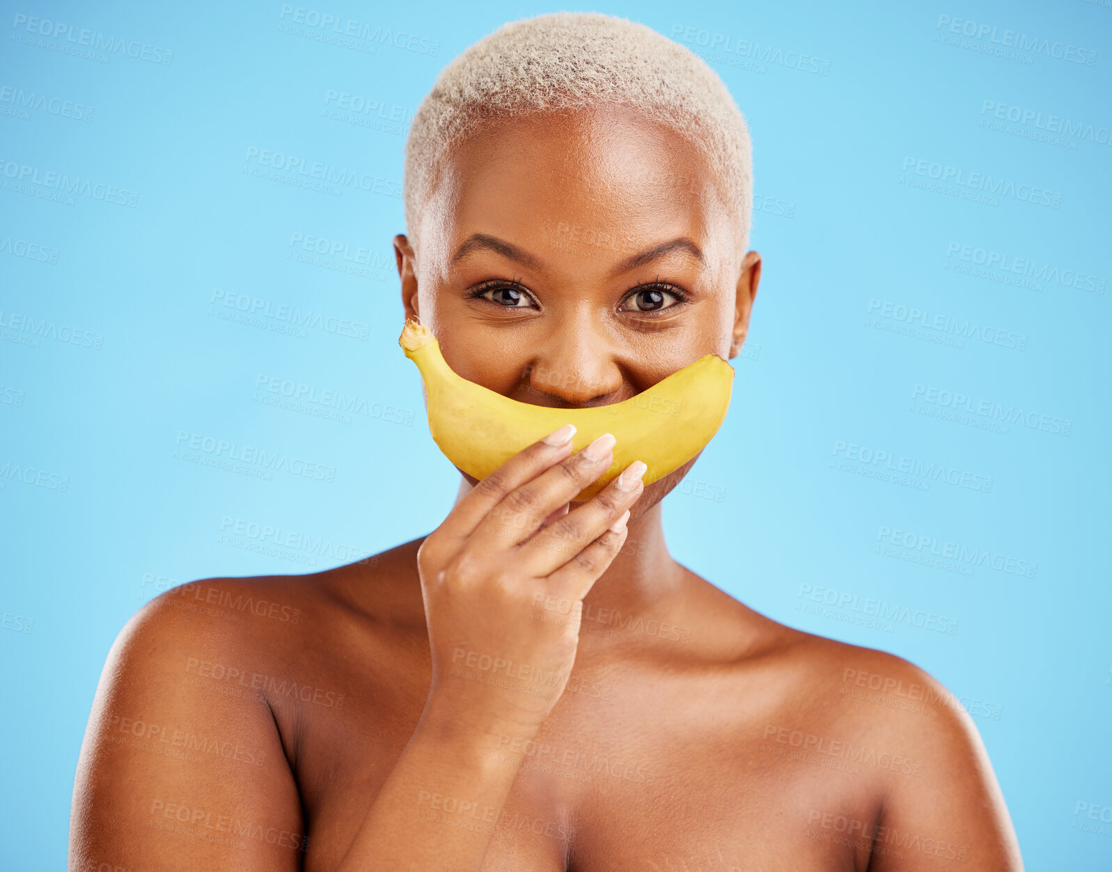 Buy stock photo Black woman, banana and mouth for potassium, vitamin or fiber against a blue studio background. Portrait of happy African female person with organic fruit smile for health or wellness on mockup space