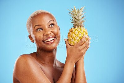 Buy stock photo Happy black woman, pineapple and thinking for diet or natural nutrition against a blue studio background. Thoughtful African female person in wonder with organic fruit for vitamin, fiber or wellness