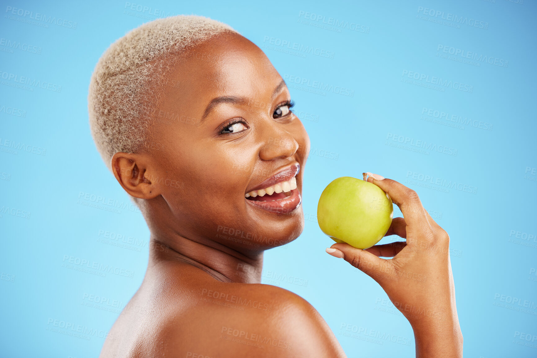 Buy stock photo Happy black woman, portrait and apple for diet, nutrition or health and wellness against a blue studio background. Face of African female person with natural organic fruit for vitamin, fiber or food