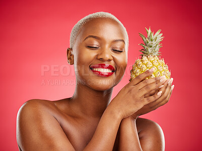 Buy stock photo Pineapple, beauty and face of a happy woman in studio for healthy food, diet or fruit. Black female model with makeup on red background for wellness glow, natural cosmetics and tropical skin care