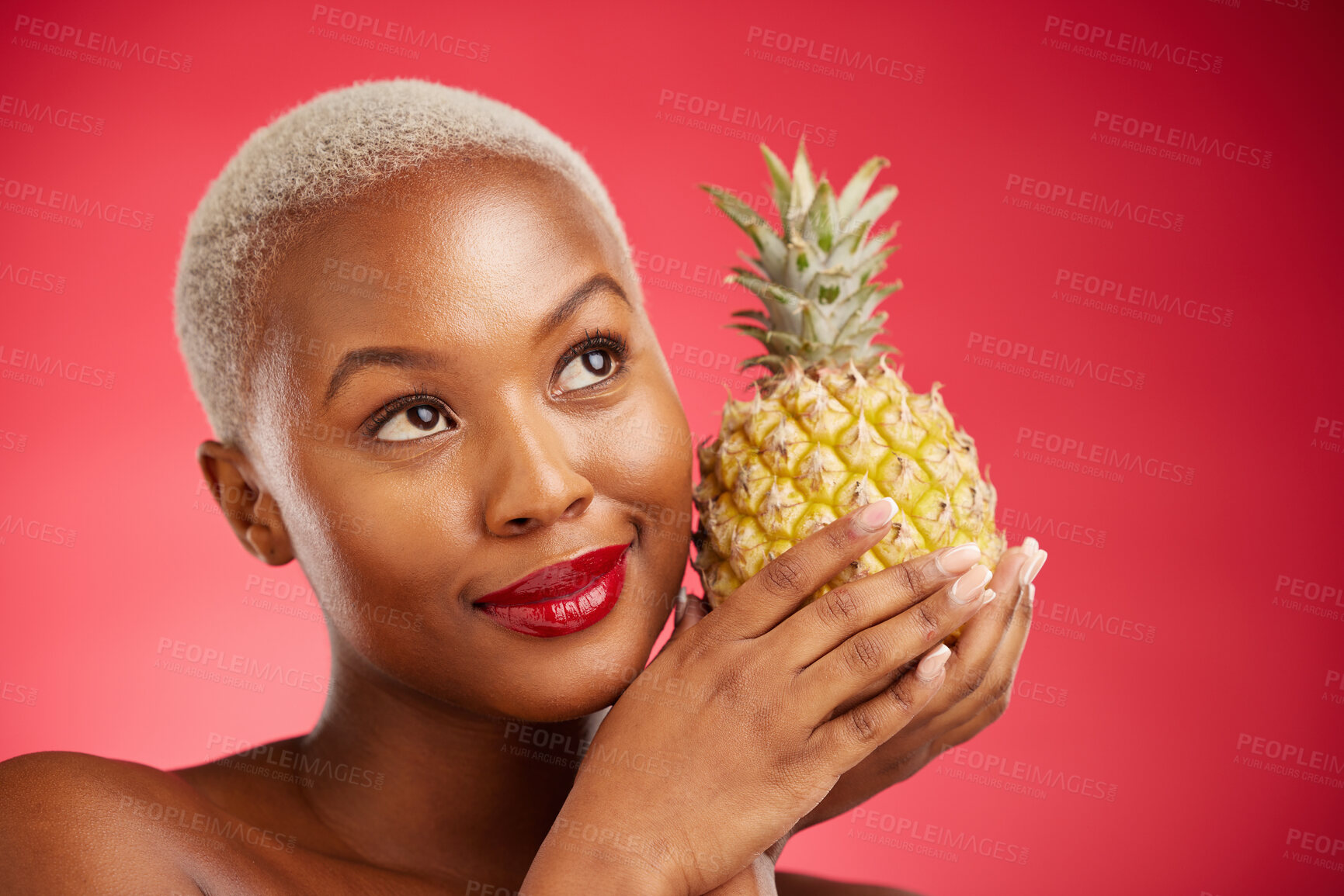 Buy stock photo Thinking, pineapple and face of a woman in studio for healthy food, diet or fruit. Black female model with makeup on red background for wellness glow, natural cosmetics and skin care or beauty