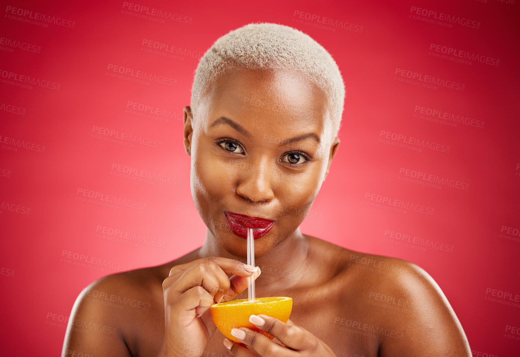 Buy stock photo Black woman, portrait and drinking orange for vitamin C, diet or natural nutrition against a red studio background. African female person with organic citrus fruit, juice and straw on mockup space