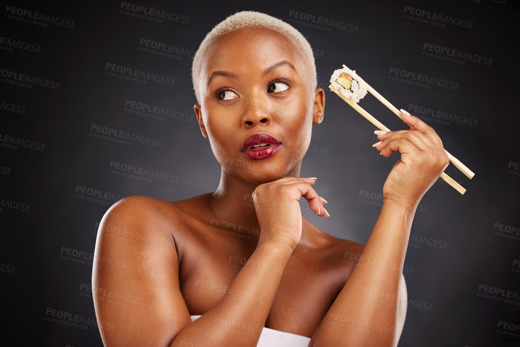 Buy stock photo Face, thinking and woman with sushi and chopsticks in studio for healthy eating, beauty or food. Black female model with makeup idea on dark background for wellness glow, diet or seafood advertising