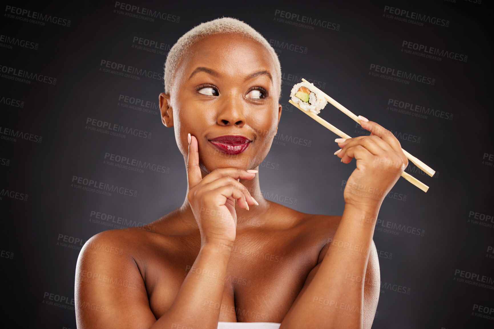 Buy stock photo Sushi, thinking and face of a woman with chopsticks in studio for healthy eating, beauty or food. Black female model with makeup on dark background for wellness glow, diet or seafood advertising idea