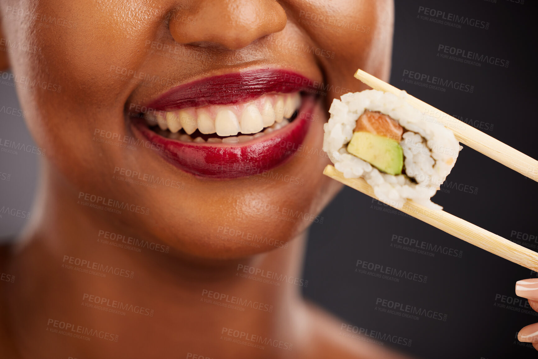 Buy stock photo Mouth, eating and woman with sushi and chopsticks in studio for healthy food or teeth. Black female model with makeup on dark background for wellness glow, diet and seafood or salmon closeup
