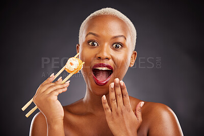 Buy stock photo Face, surprise and woman with sushi and chopsticks in studio for healthy eating, beauty or food. Black female model with makeup on dark background for wellness glow, wow diet or seafood portrait
