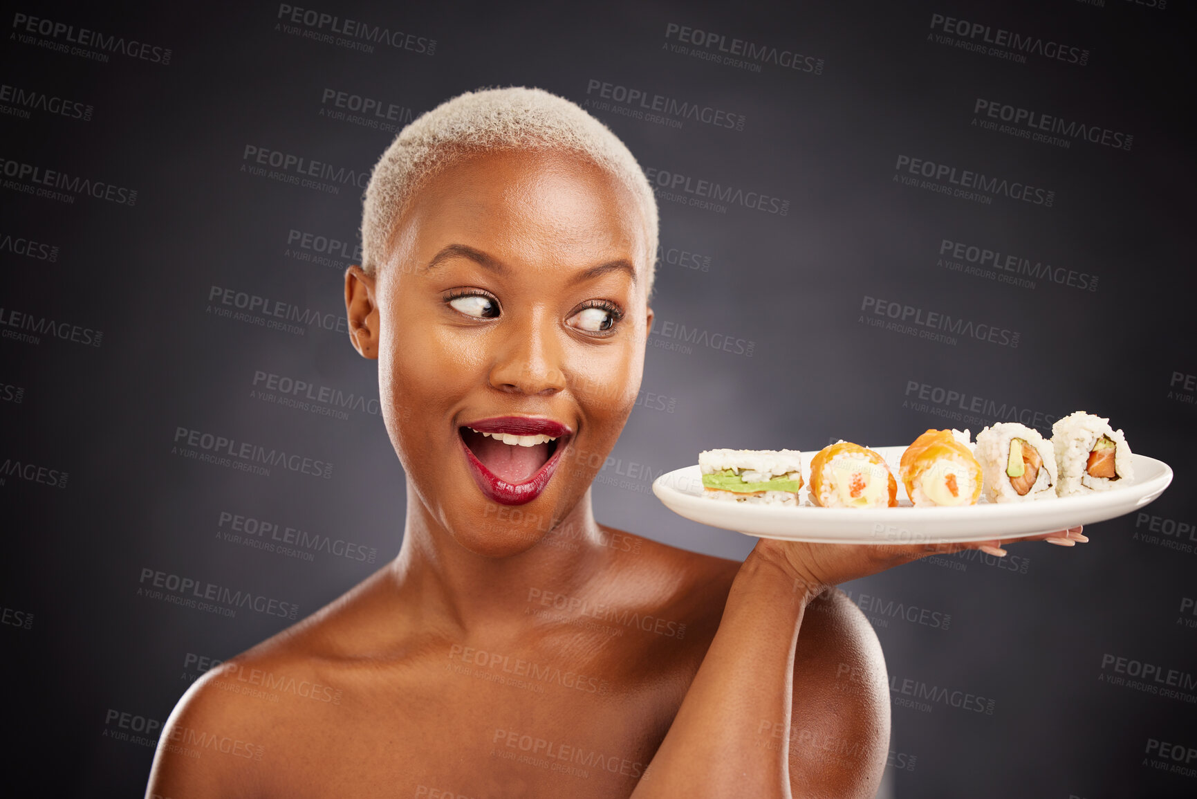 Buy stock photo Face, surprise and woman with sushi plate in studio for healthy eating, beauty or food. Excited black female model with makeup on dark background for wellness glow, wow diet or seafood advertising
