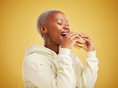 Buy stock photo Hamburger, eating and happy woman or student on a studio, yellow background for restaurant promotion or deal. Hungry and excited african person or customer experience with fast food and burger bite