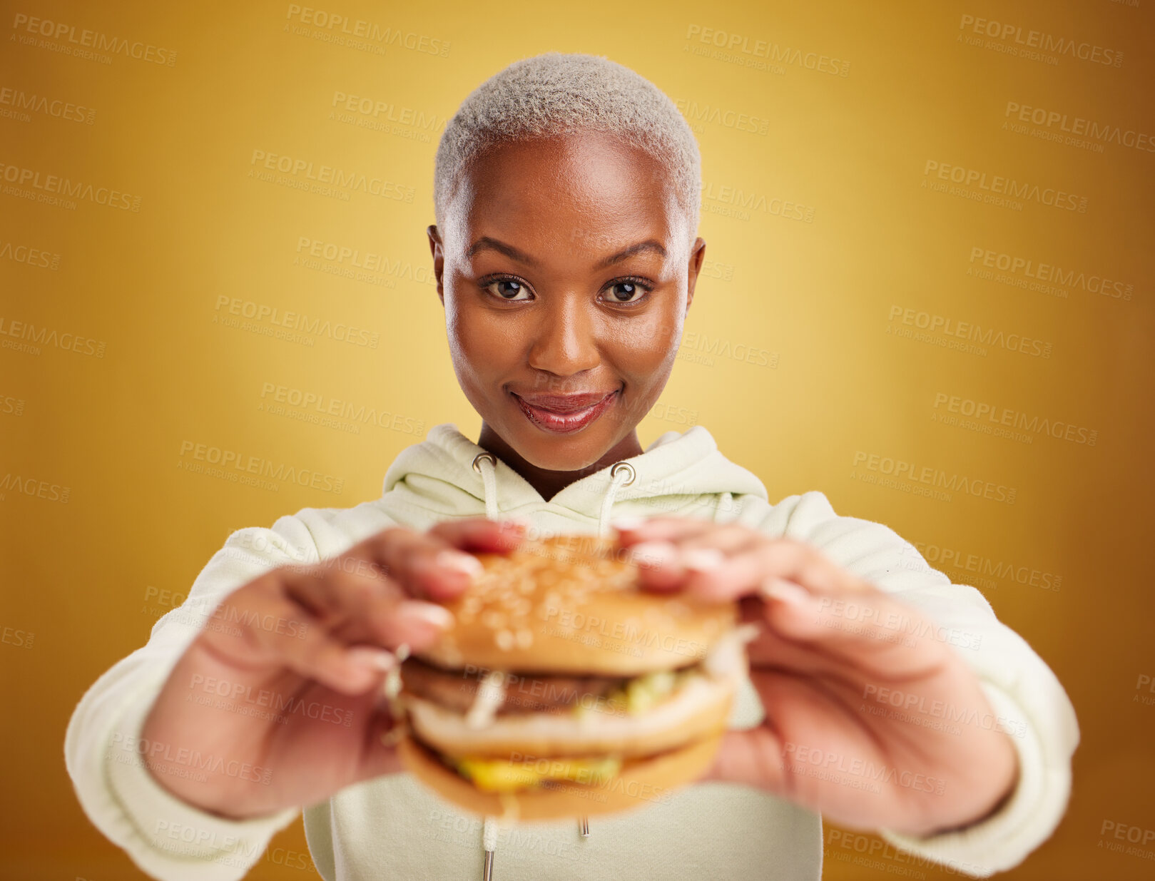 Buy stock photo Burger, offer and portrait of woman or student on studio yellow background in restaurant promotion or deal. Giving, eating and young african person for customer experience with fast food or hamburger