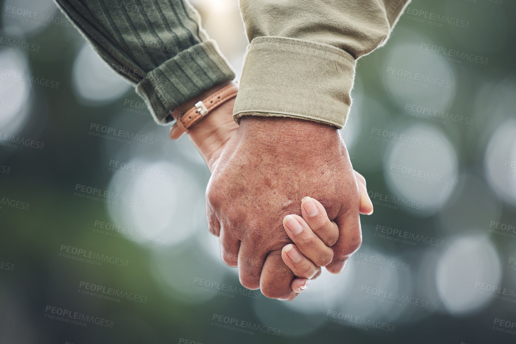Buy stock photo Love, holding hands and couple together in partnership, marriage or people with trust, bonding or moment in nature with bokeh background. Hand, support and unity with a soulmate or romantic partner