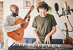 Happy, piano and friends with guitar recording music in home studio together. Electric keyboard, instrument and microphone of singer with teamwork, headphones and men in production of acoustic sound.