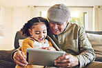 Young girl, grandfather and tablet, relax together and watch cartoon or e learning with games while at home. Bonding, love and spending quality time, old man and female child with gadget and internet