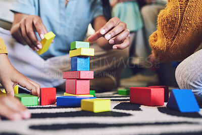Buy stock photo Hands, building blocks and color, learning and development with people at home playing games with toys. Relax on living room floor, parents and children with education activity, family and bonding 