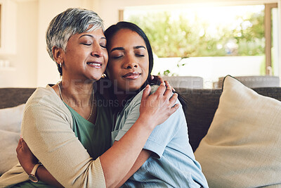 Buy stock photo Family, senior woman hugging her daughter and love with people sitting on a sofa in the home living room during a visit. Smile, trust or comfort with an elderly female parent embracing an adult child