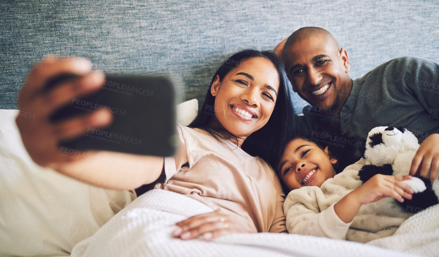 Buy stock photo Family selfie, parents and child in a bed together with love, care and security or comfort. Woman, man and kid relax with a happy smile for quality time, memory or profile picture in a home bedroom