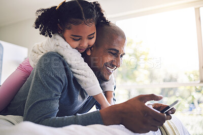 Buy stock photo Father, girl and phone in bedroom together, relax and search for funny video, meme and happy in family home. Man, young daughter and smartphone on bed, watch comic movie or streaming cartoon on app
