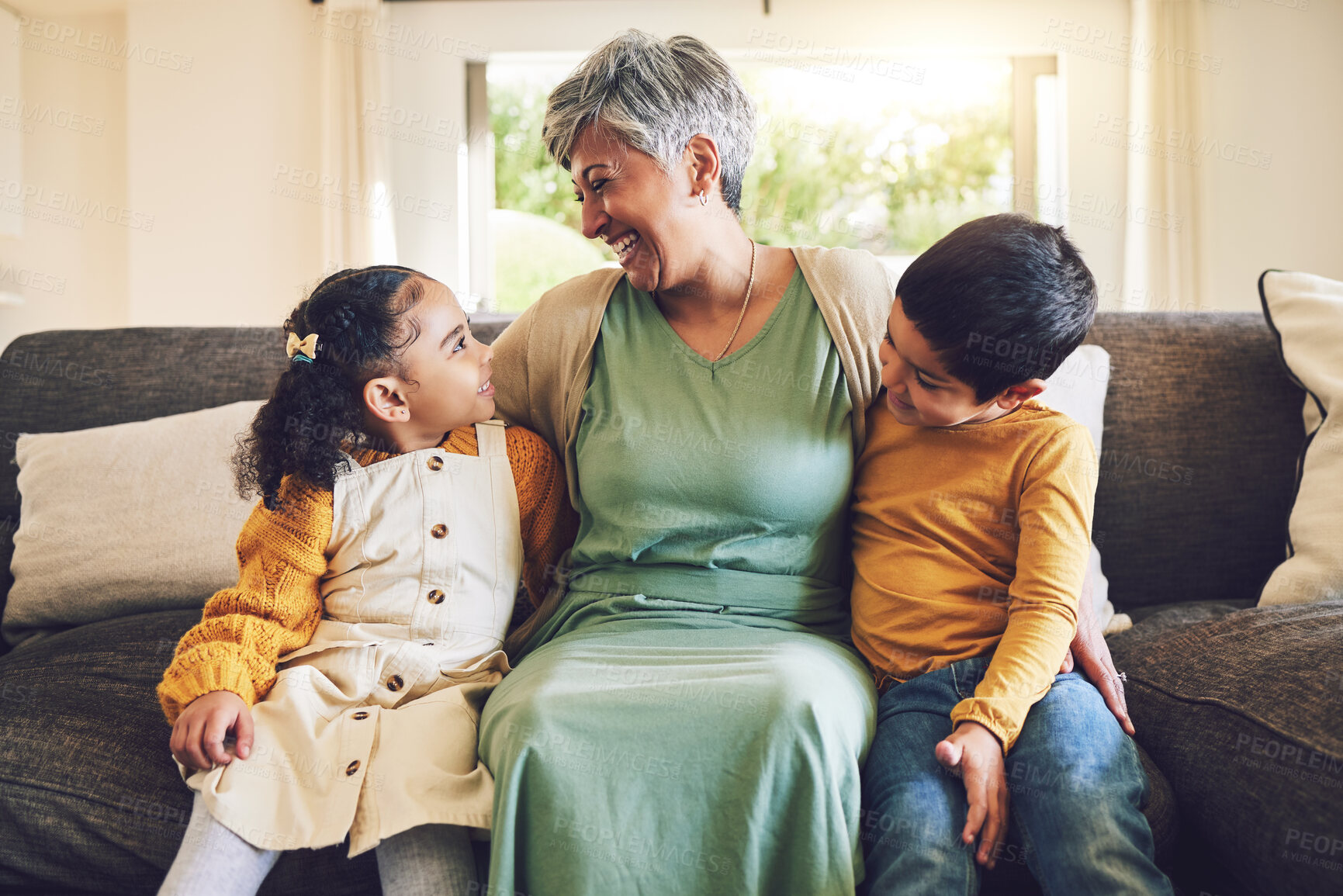 Buy stock photo Laughing, grandmother or happy kids on a sofa with love enjoying quality bonding time together in family home. Smile, affection or funny senior grandparent hugging children siblings on house couch