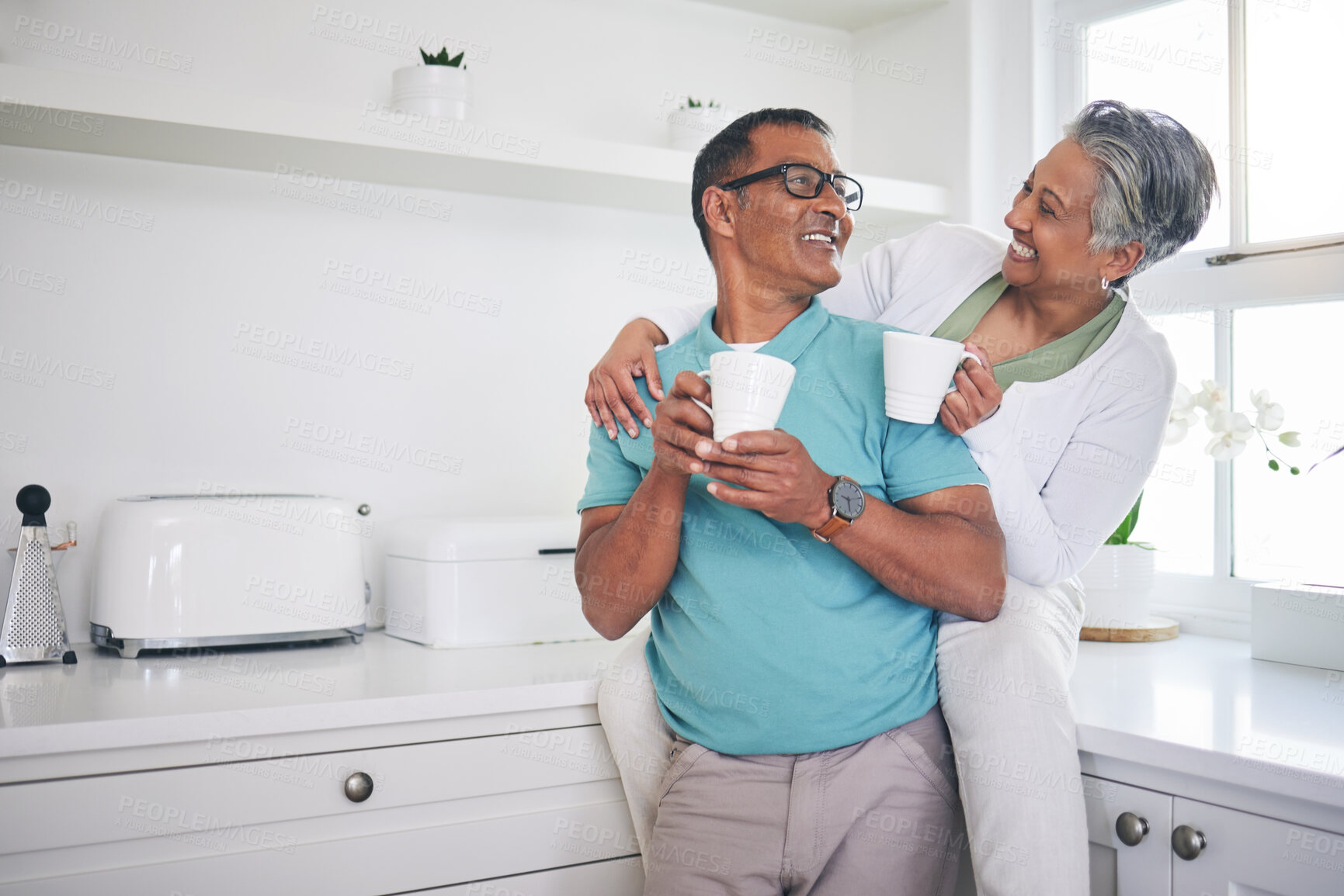 Buy stock photo Love, coffee and happy with old couple in kitchen, for morning, relax and hug. Happiness, smile and peace with senior man and woman drinking tea at home for conversation, wake up and embrace