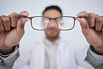 Hands, man and optician with glasses for vision, eyesight and eye care prescription lens. Closeup of doctor, optometrist and frame for eyewear, test and consulting for optical assessment in clinic 