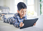 Young boy, tablet and games or cartoon streaming online with internet, e learning and relax on carpet in house. Watch animation film, male kid at home and connection, entertainment and subscription